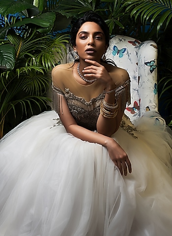 A stunning soirée look with an opulent embellishment accented white gown paired with stacked bangles and a dainty pair of earrings and necklace. by BELLE OF THE BALL