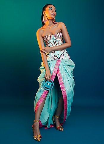 Seeking a glamour quotient that stands out? Experiment with unconventional draping with a bright Masaba saree pairing it with an artsy corset by Manish Arora. A miniaudiere bag and statement earrings are all you need to anchor the glam by Extra Dose of Glam